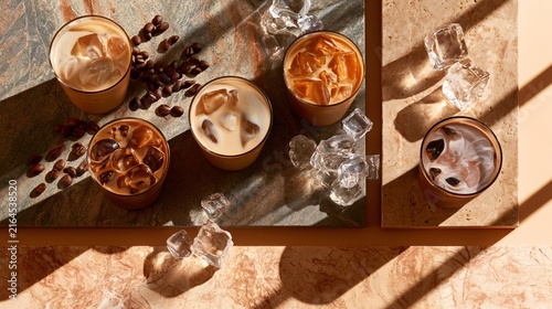 A premium flat lay featuring iced coffee, caramel iced coffee, vanilla iced coffee, mocha iced coffee, crystal-clear ice cubes, roasted coffee beans and milk swirls