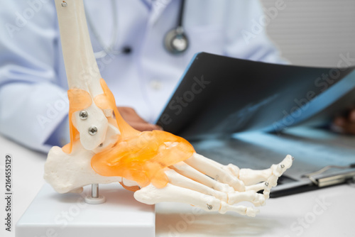 Foto Doctor examining foot ankle  joint bone radiography xray film.