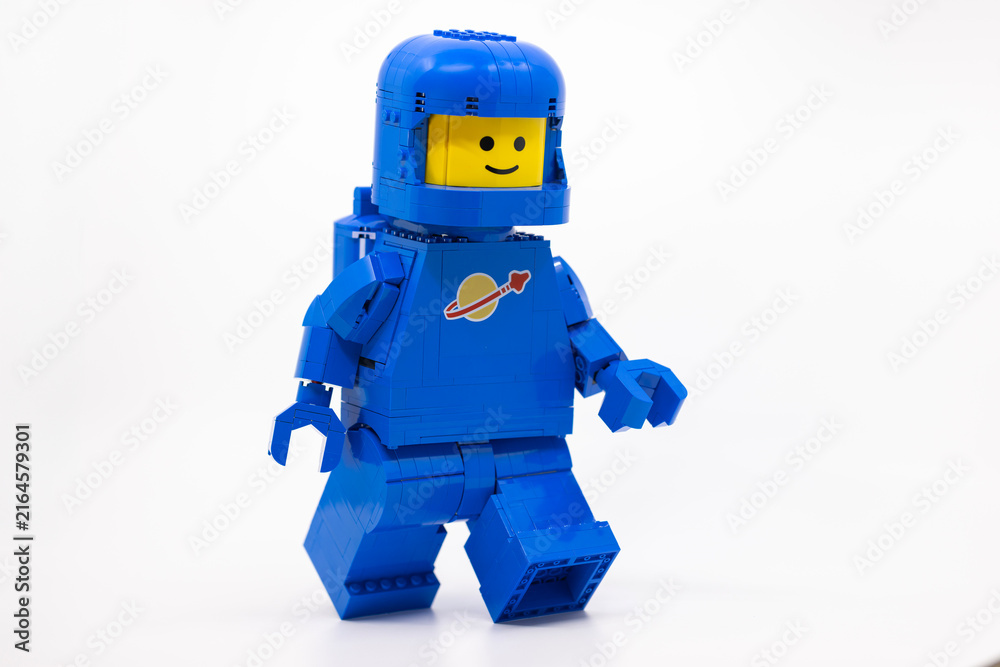Naklejka premium Hong Kong, June 8, 2026: A giant classic spaceman strides forward, carrying a tiny companion perched atop his helmet.