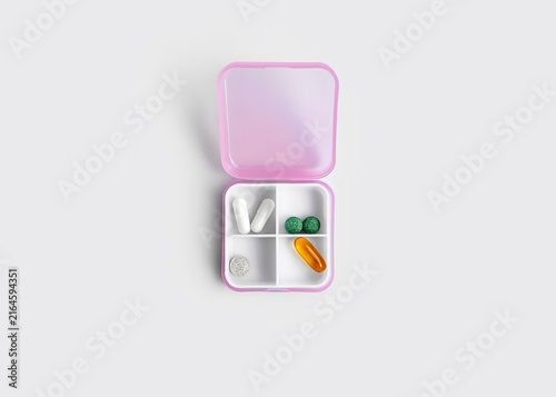 Pink Plastic Pill Organizer with Medication Isolated