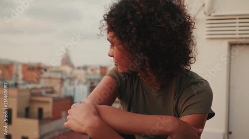 Reflective Young Woman Enjoys Serene City Rooftop View