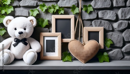 a white plush teddy bear blank photo frames and a heart decor sit on a rope shelf against a gray stone wall with ivy