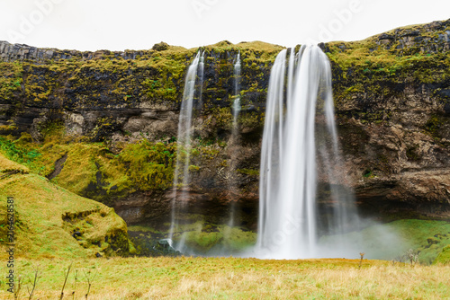 Waterfall flows from a mossy cliff