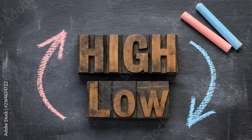 High and low words on black chalkboard with chalk arrows
