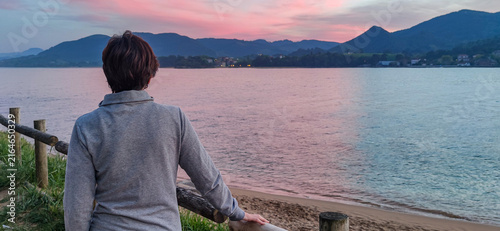 Quadro su tela Person contemplating sunset over ajo river estuary in ibarrangelu
