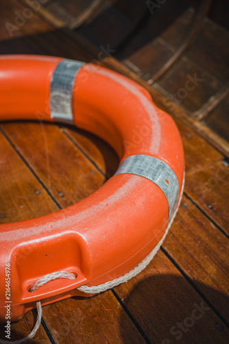 Quadro su tela Bright orange lifebuoy on a traditional wooden boat at Lago di Braies in the Italian Dolomites, representing boating, travel, safety and alpine tourism