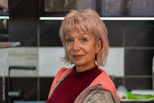Foto Confident mature woman posing in modern kitchen with soft smile