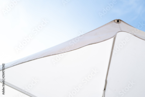 Close-up of white sunshade corner under sunny sky