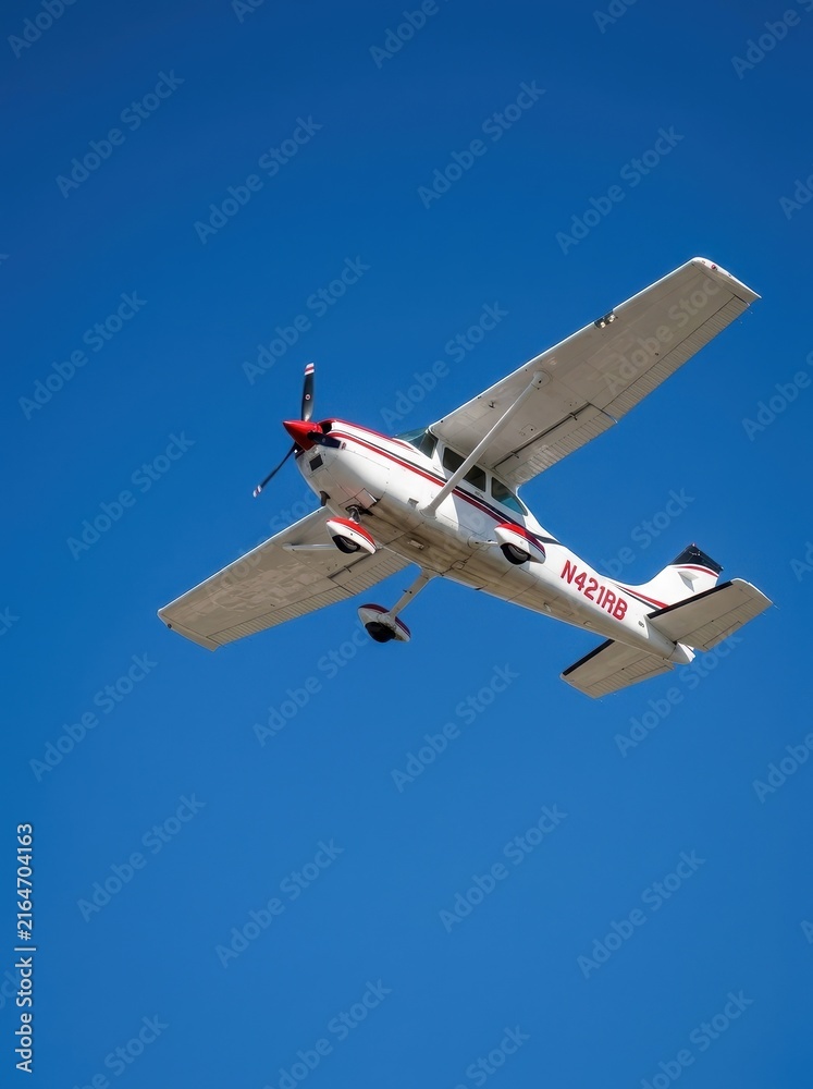 Obraz premium Small Propeller Airplane Flying in a Clear Blue Sky - Single Engine Private Aircraft in Flight