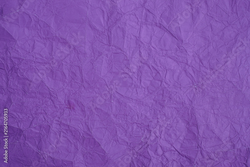 Crumpled purple paper texture with detailed folds, creases, ridges, and natural light and shadow across the surface, creating an abstract textured background