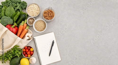 Weekly food budget planning layout with vegetables and notebook