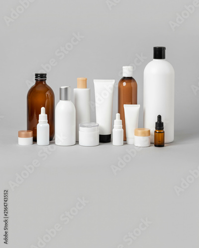 Assorted cosmetic and skincare bottles in white and brown containers