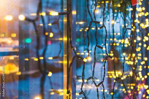 Festive lights glow against glass. Winter decoration adds warmth