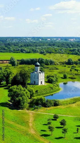 Vertical video. Russia, Bogolyubovo. Drone footage of Church of the Intercession on the Nerl. Orthodox church and a symbol of medieval Russia. Drone footage, Departure of the camera. Rich colors