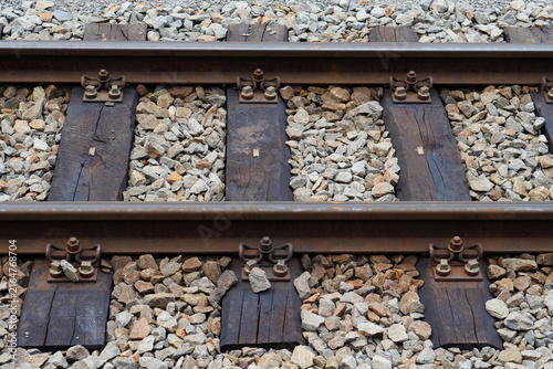 Foto Close Up View of Steel Railway Track with Wooden Ties and Gravel