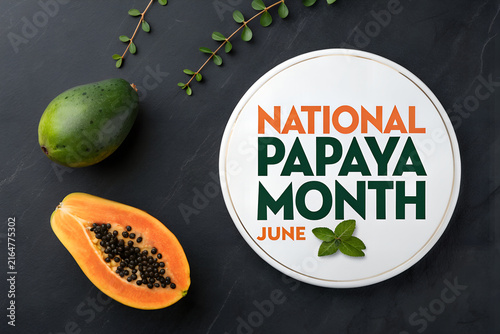 National papaya month june advertising sign with fresh tropical papaya and leaves on dark background