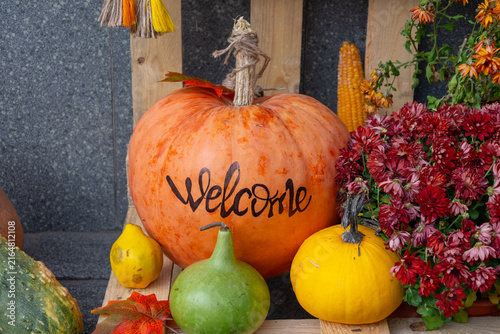 Autumn welcome pumpkin display with gourds, flowers, and seasonal decor