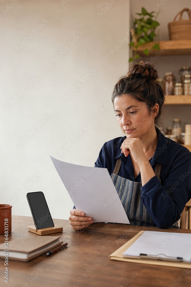 Fototapeta premium Small business owner checking a bank transfer request