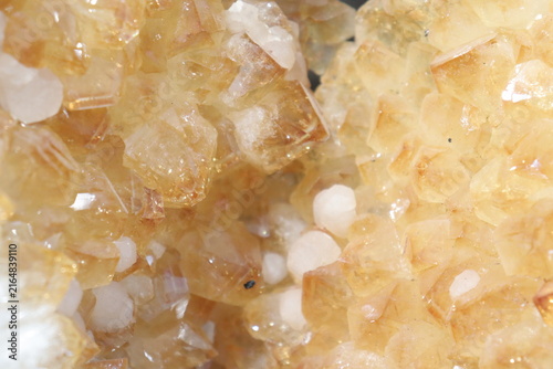 A close-up of a yellow geode of citrine. Mineral, crystal and gemstone and geology. Citrine druse and raw stone. Yellow background with minerals and crystal points. Geogical formation.