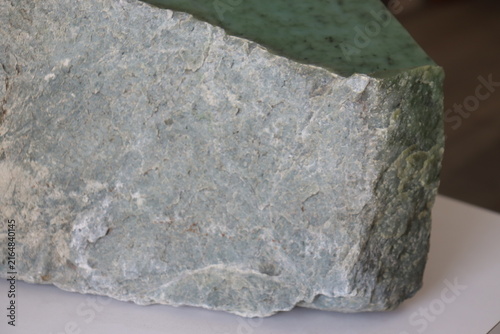 Close-up of a nephrite jade from Quebec. Green stone background and jade. Raw and polished jade. Geology science and mineral from Quebec.