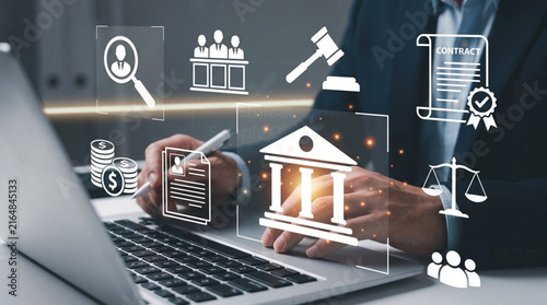 Lawyer or businessman using laptop with holographic icons of law, finance, and legal compliance