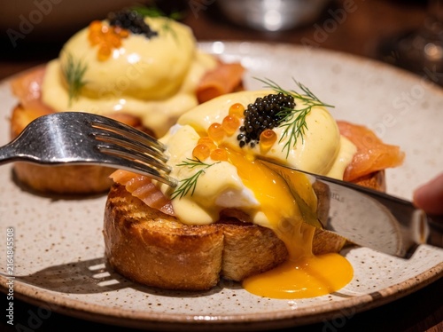 Delicious eggs Benedict with smoked salmon and caviar on toast  