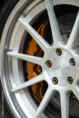 Obraz na płótnie Close-up of silver custom alloy wheel with gold brake caliper