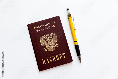 Foto Russian Federation passport with gold emblem and text alongside a yellow and black pen on a white background