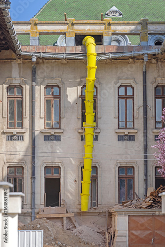 Canvas Print Yellow Plastic Long Chute for Building Debris at Construction Site in Craiova Ro