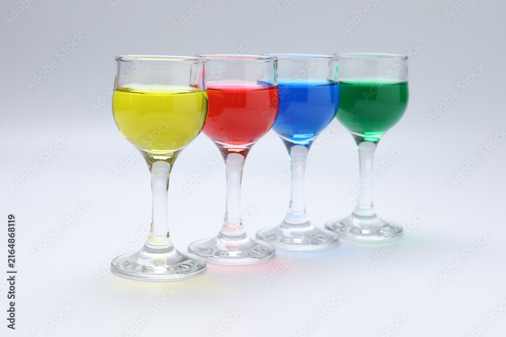 Fototapeta premium Colorful drinks in glasses on light grey background, closeup