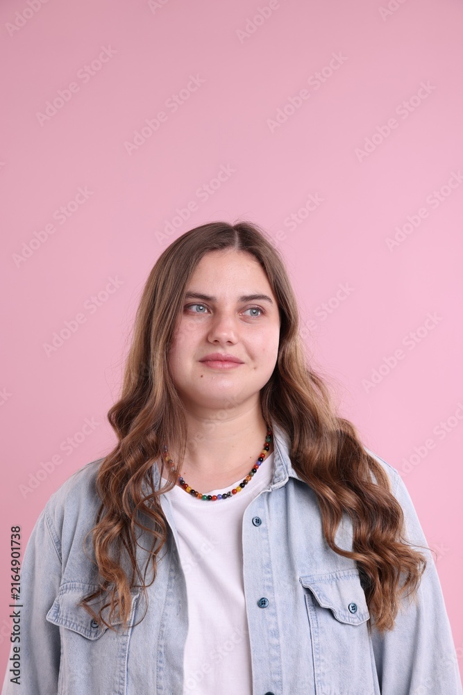 Fototapeta premium Plus size model in denim shirt on pink background. Beautiful young overweight woman