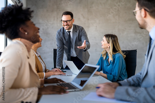 Multicultural professional businesspeople working together on research plan in boardroom.