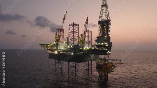 Offshore drilling rig - jack up and offshore platform during sunset for oil and gas exploration and production. 