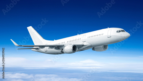 Side angle view of white commercial passenger jet airplane cruising in deep blue sky above clouds flight journey travel transport concept stock photo