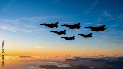 Fighter jets flying in formation across a colorful sunset sky