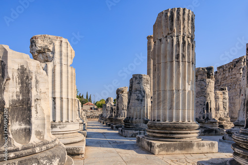 Quadro su tela Ancient temple ruins with stone columns under clear blue sky
