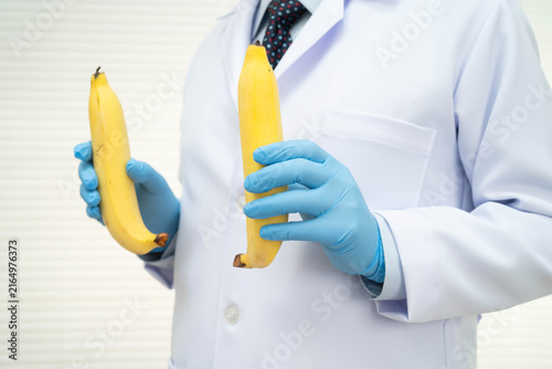 Quadro su tela Male doctor stands holding a banana, penis health.