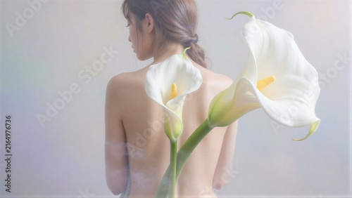 A woman's back with two white calla lilies, soft light and gentle smoke.