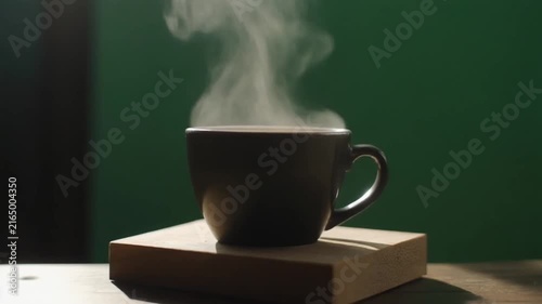 Steaming black coffee cup motion clip featuring soft rising vapor against a deep green background backdrop