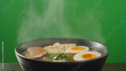 Steaming ramen noodle bowl with soft boiled eggs and savory broth in motion video footage clip
