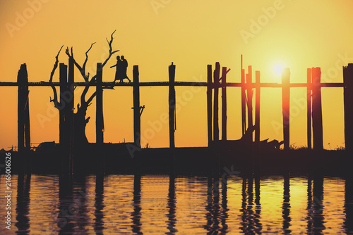 Silhouette of monks across the U Bein Bridge in the evening. Mandalay Myanmar