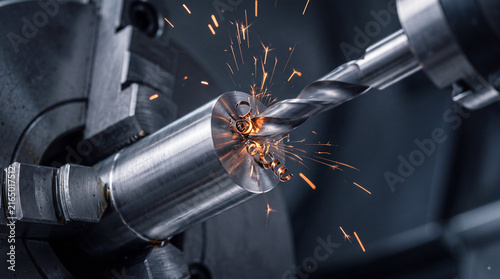 Industrial CNC machining close-up with cutting tool shaping metal workpiece on lathe, sparks flying in precision manufacturing workshop environment