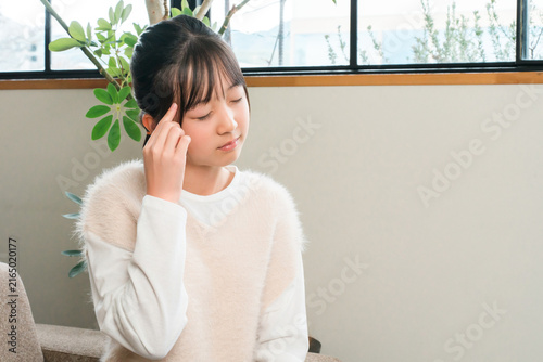 Bild auf Leinwand Elementary and middle school girls clutching their temples due to headaches