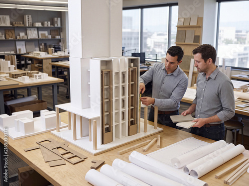 Two men working on a model of a building