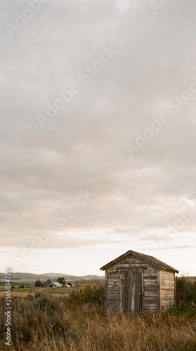 Old Weathered Wooden Utility Shed in Rural Countryside Landscape Overcast Sky Stock Photo
