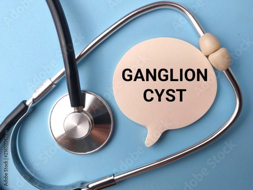 Foto A speech bubble paper cutout labeled GANGLION CYST rests inside the loop of a st