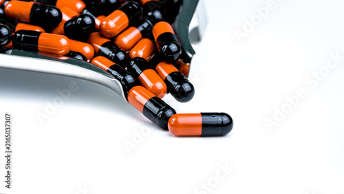 Orange-black capsule pills on drug tray. Antibiotics drug resistance. Drug use with reasonable. Antimicrobial capsule pills. Pharmaceutical industry. Infection treatment medicine in hospital.
