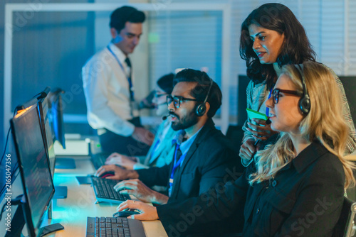 Cybersecurity team monitoring security information and event management dashboard in dark war room