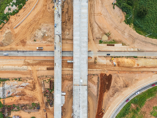Drone shot of highway and overpass construction site with vehicles and road in a rural place