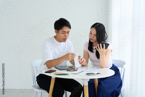 Foto Young Japanese Man and Woman Discussing Household Finances at Table